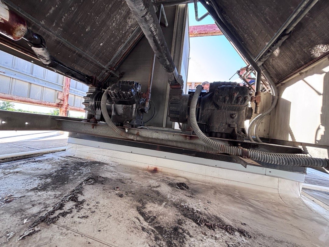 The original compressors inside the Infinity Homes rooftop unit before replacement.
